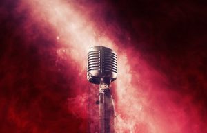 Vintage microphone against red and white smoky background